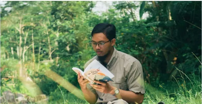 A reader studying outdoors with a book